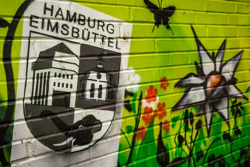 Graffiti auf einem Mauer - Eimsbütteler Wappen, Blumen, Gras und Biene